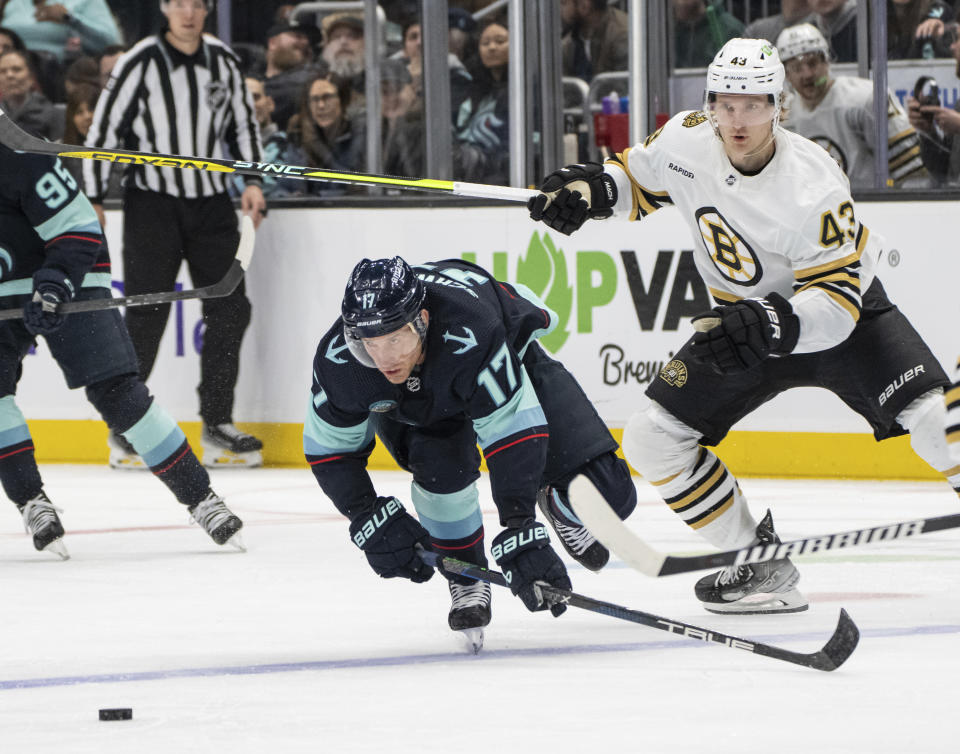 Seattle Kraken forward Jaden Schwartz (17) scrambles for the puck against Boston Bruins forward Danton Heinen, right, during the second period of an NHL hockey game, Monday, Feb. 26, 2024, in Seattle. (AP Photo/Stephen Brashear)