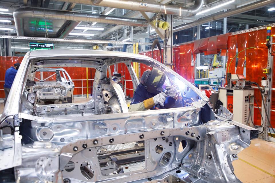 A worker welds a car body at the Volkswagen plant in Chattanooga, Tenn.