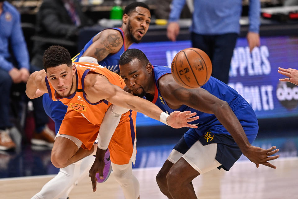 DENVER, CO - JUNE 11:  Devin Booker #1 of the Phoenix Suns is defended by Paul Millsap #4 of the Denver Nuggets in Game Three of the Western Conference second-round playoff series at Ball Arena on June 11, 2021 in Denver, Colorado. NOTE TO USER: User expressly acknowledges and agrees that, by downloading and or using this photograph, User is consenting to the terms and conditions of the Getty Images License Agreement. (Photo by Dustin Bradford/Getty Images)