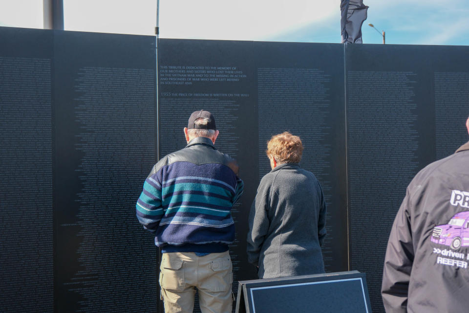 A couple looks over the wall at the opening ceremony for the Vietnam Traveling Memorial Wall Wednesday at the Ussery-Roan Texas State Veterans Home in Amarillo.