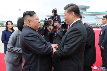 North Korean leader Kim Jong Un shakes hands with Chinese President Xi Jinping during Xi's visit in Pyongyang