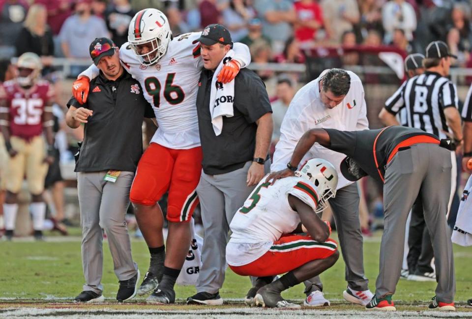 Miami Hurricanes defensive lineman Jonathan Ford (96) and safety Amari Carter (5) are injured in the first half during game against the Florida State Seminoles at Doak Campbell Stadium in Tallahassee on Saturday, November 13, 2021