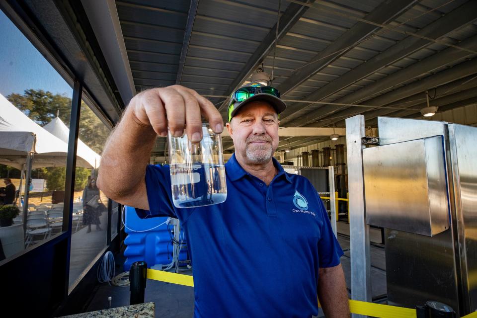 Polk County Utilities Water Operator Buddy Gary holds a beaker of water after it has been filtered during a tour of the new Cherry Hill Water Production Facility in Kathleen