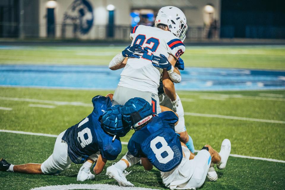 Bartlesville's Chase Eaves, Damien Niko go low, and Adyn Peugh cleans up high on Ponca City's Kooper Rich during a 2023 scrimmage at Custer Stadium.