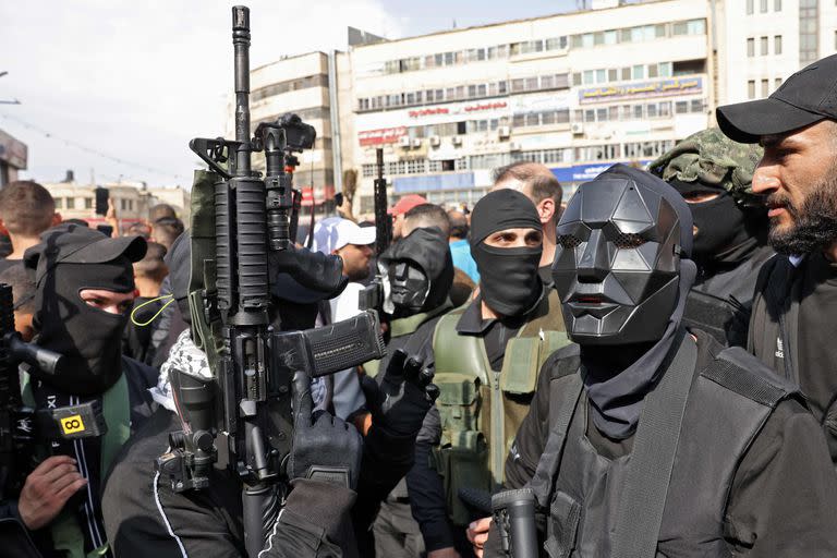 Palestinian militants attend the funeral of those killed in an overnight Israeli raid, in the occupied West Bank city of Nablus on October 25, 2022. - Six Palestinians were killed in sweeping Israeli raids in the occupied West Bank, the Palestinian Health Ministry reported, in what the army said was an assault targeting the emerging "Lion's Den" armed group. (Photo by RONALDO SCHEMIDT / AFP)