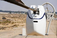 A small, four-seat pod made by uSky glides above the sands of a test track in Sharjah, United Arab Emirates, Thursday, Oct. 28, 2021. The futuristic transit solution is being promoted by a Belarusian firm that hopes to secure contracts here in the near future. However, uSky has ties back to a Belarusian investment firm called SkyWay that has seen multiple nations in Europe and elsewhere issue warnings to investors that they "may be involved in a scam." (AP Photo/Jon Gambrell)