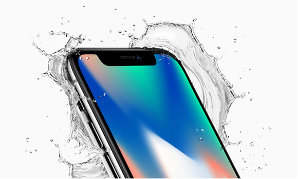 The iPhoneX featuring a rainbow background on its screen is shown with water splashing around it and a white background