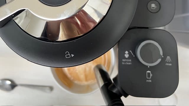 Top view of the milk carafe, and coffee outlet, showing the locking icon on the Nespresso Vertuo Lattissima's lid