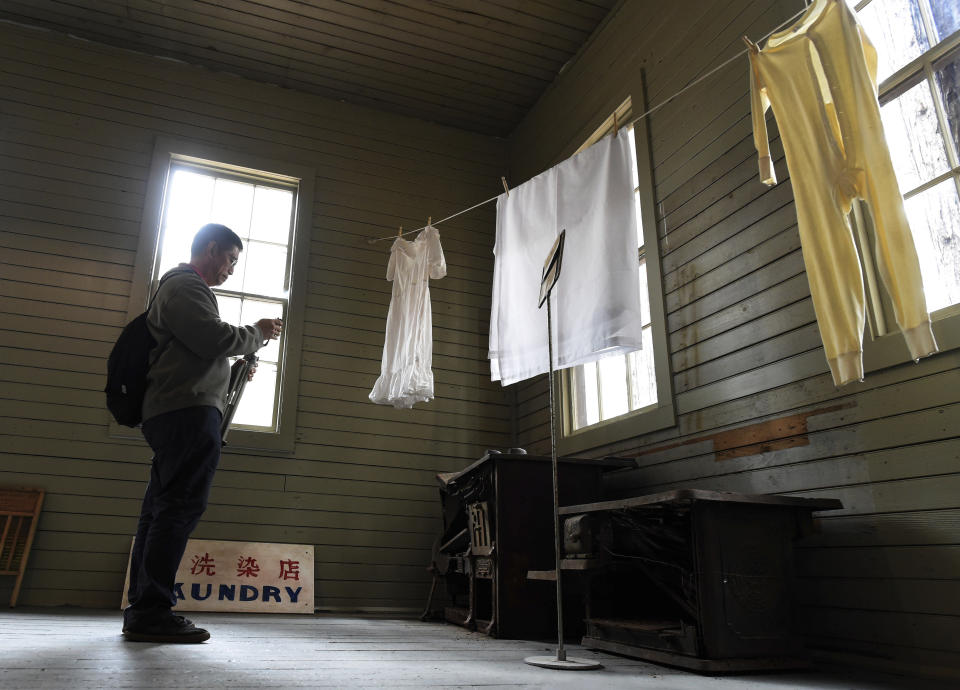 In this Friday, Oct. 1, 2021, photo Ricky Leo of Thousand Oaks takes a photo of old stoves in the restored 1917 Chinese laundry building at Wawona at Wawona in Yosemite National Park, Calif. Officials unveiled on Friday a new sign and exhibit inside a building originally used as a laundry by Chinese workers at Yosemite's Wawona Hotel, formally recognizing Chinese Americans' contributions to the national park's history. (John Walker/The Fresno Bee via AP)