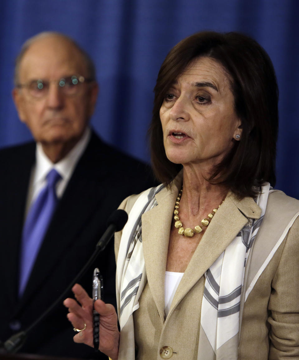 Camille Biros addresses a reporter's question during a news conference Tuesday Nov. 13, 2018, in Philadelphia. Biros and Ken Feinberg, not pictured, are administrators of claims submitted to the Independent Reconciliation and Reparations Program, a new clergy child sexual abuse victim compensation fund set up by the Roman Catholic Archdiocese of Philadelphia. George Mitchell, background, is chairing the committee. (AP Photo/Jacqueline Larma)