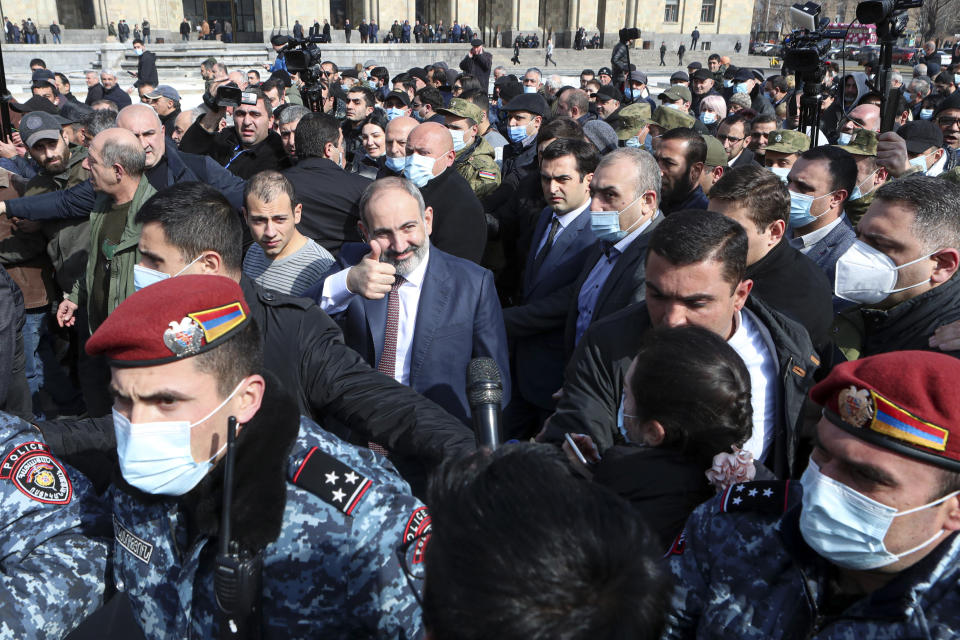 Armenian Prime Minister Nikol Pashinyan, center, gestures as arriving at the main square in Yerevan, Armenia, Thursday, Feb. 25, 2021. Armenia's prime minister has spoken of an attempted military coup after facing the military's General Staff demand to step down. The developments come after months of protests sparked by the nation's defeat in the Nagorno-Karabakh conflict with Azerbaijan. (Hayk Baghdasaryan/PHOTOLURE via AP)