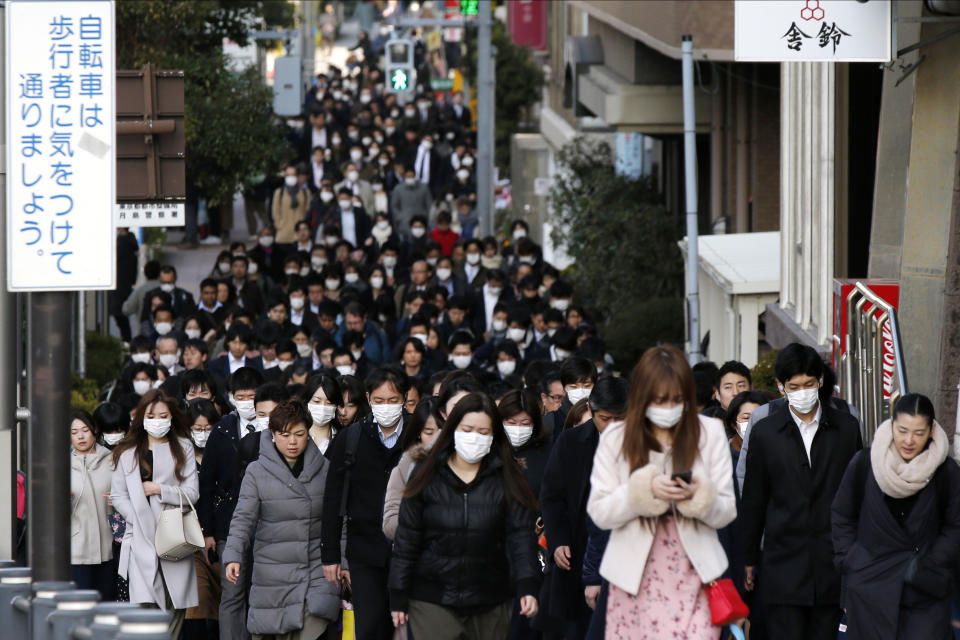 People wear masks as they commute during the morning rush hour Thursday, Feb. 20, 2020, in Chuo district in Tokyo. A test event for the Tokyo Olympics scheduled for later this month that would have involved some non-Japanese athletes is being rejiggered because of fear of the spreading virus from China. It will now involve only Japanese athletes. (AP Photo/Kiichiro Sato)