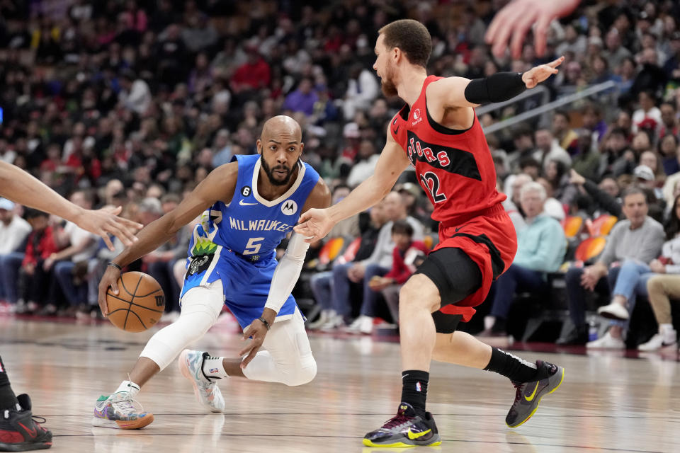 Milwaukee Bucks guard Jevon Carter (5) dribbles around Toronto Raptors guard Malachi Flynn (22) during first half of an NBA basketball game in Toronto, Sunday, April 9, 2023. (Frank Gunn /The Canadian Press via AP)