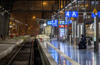 A woman sits on an empty platform in the central train station in Frankfurt, Germany, Friday, Dec. 8, 2023, when train drivers of the GDL union went on a 24-hour-strike. (AP Photo/Michael Probst)