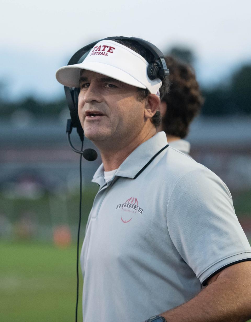 Aggies head coach Rhett Summerford communicates with his assistant coaches during the Northview vs Tate football game at Tate High School in Cantonment on Thursday, Sept. 7, 2023.