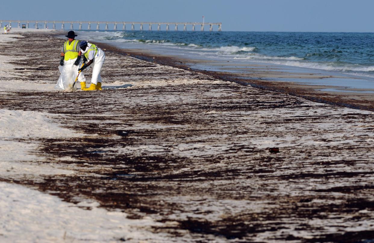 Crews work to clean up oil from the Deepwater Horizon oil spill washed ashore at Pensacola Beach in Pensacola in this June 2010 file photo. Representatives from the nonprofit Oceana are urging people to weigh in on a federal proposal to award one lease off of Alaska and as many as 10 in the Gulf of Mexico at a Sept. 12 virtual hearing or in writing, through Oct. 6.