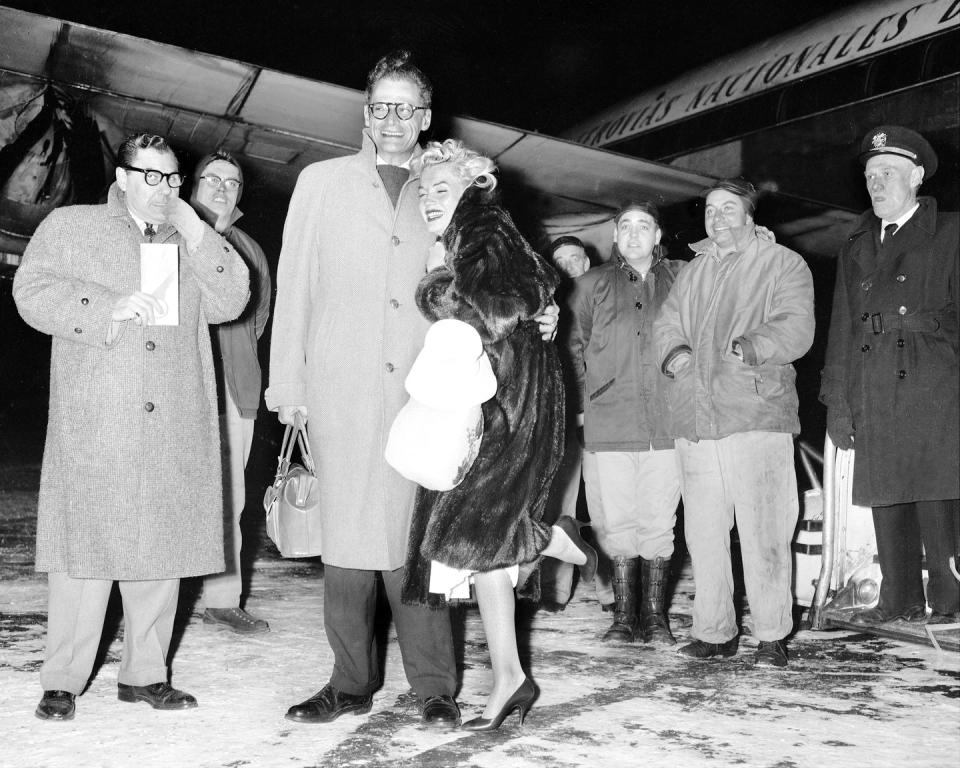 <p>Marilyn Monroe and her husband, Arthur Miller, arrive in New York City bundled up after spending the holidays in Jamaica. </p>