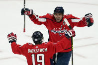 Washington Capitals left wing Alex Ovechkin (8) and center Nicklas Backstrom (19) celebrate after a goal during the second period of Game 1 of an NHL hockey Stanley Cup first-round playoff series against the Boston Bruins, Saturday, May 15, 2021, in Washington. It was later determined that the goal was scored by Capitals defenseman Brenden Dillon. (AP Photo/Alex Brandon)