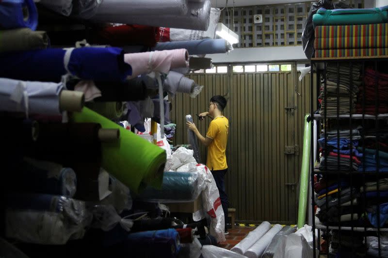 FOTO DE ARCHIVO: Un empleado selecciona un rollo de tela en la empresa Uniformes Uno, en Cúcuta, Colombia