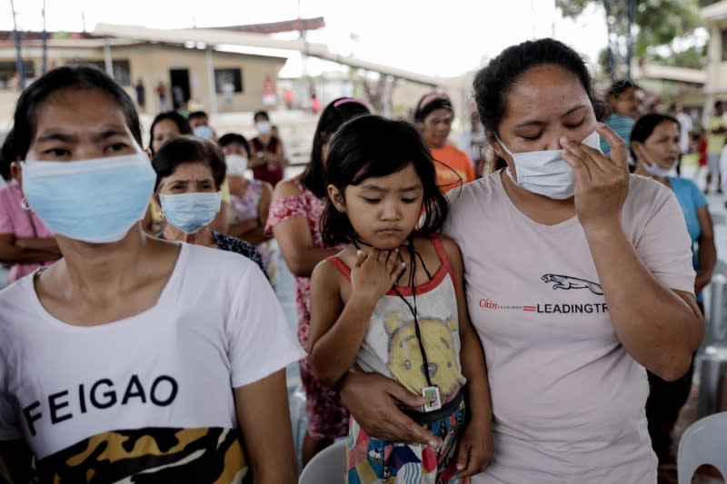 Residents displaced by Taal Volcano's eruption attend a Catholic mass in an evacuation center