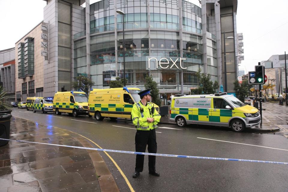 A police officer and ambulances outside the Arndale Centre in Manchester (Peter Byrne/PA) (PA Archive)