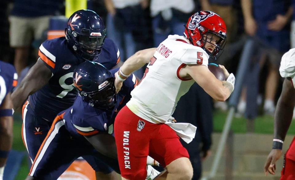 N.C. State quarterback Brennan Armstrong (5) escapes the Virginia defense on a scramble during the first half of N.C. State’s game against Virginia at Scott Stadium in Charlottesville, Va., Friday, Sept. 22, 2023.