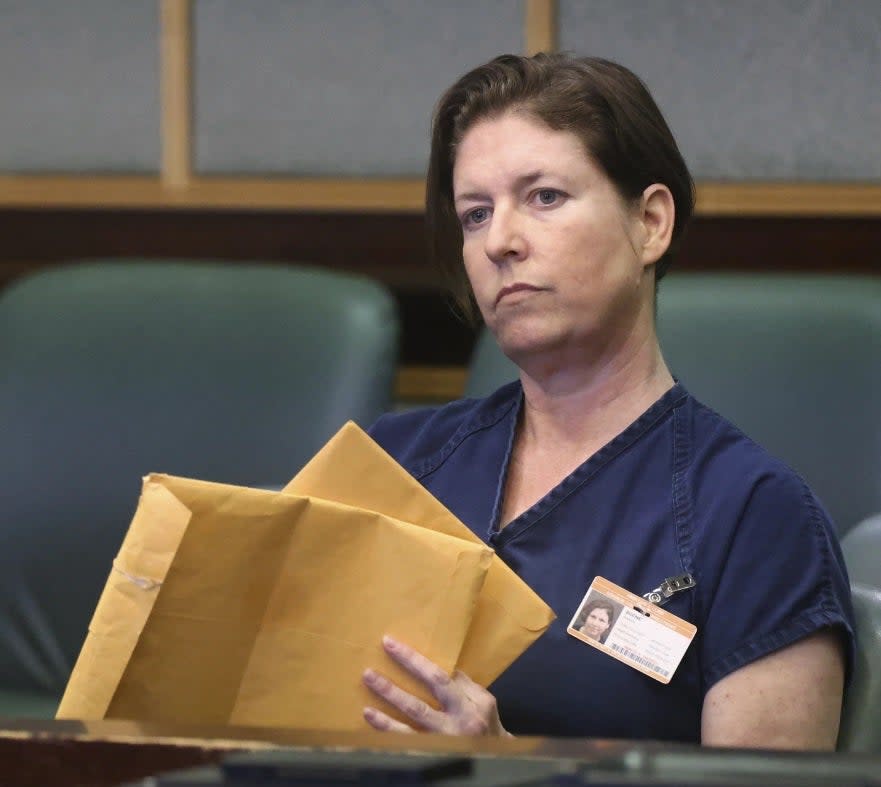 Defendant Sarah Boone holds envelopes during a pre-trial hearing in Orlando, Fla., Friday,