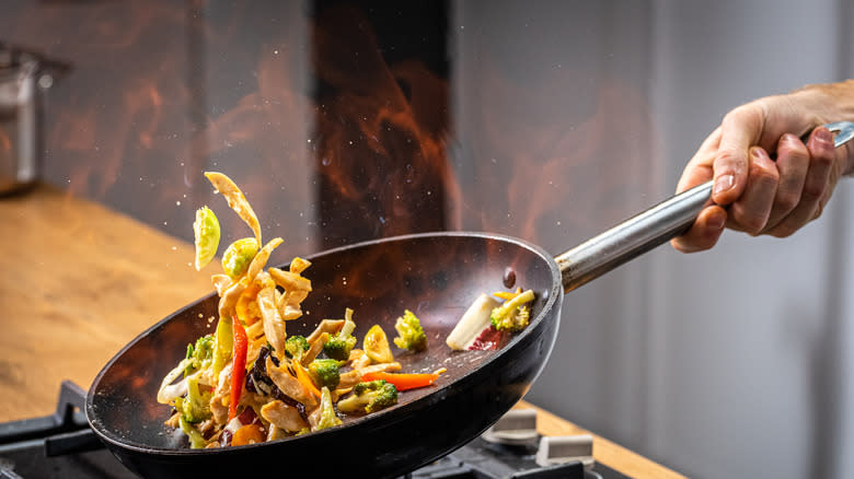 stir-fry vegetables in a wok