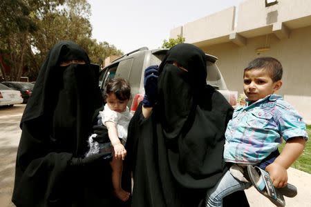 Wahida (R), 28, the wife of Jihadist Azzedine Zaini, who was killed during a U.S strike in Libya, carries her son Bara'ah, 2, as she stands with Ghofran, 18, holding her six-month-old daughter after their interview with Reuters in Maitiga prison in Tripoli, Libya May 31, 2016. REUTERS/Zohra Bensemra