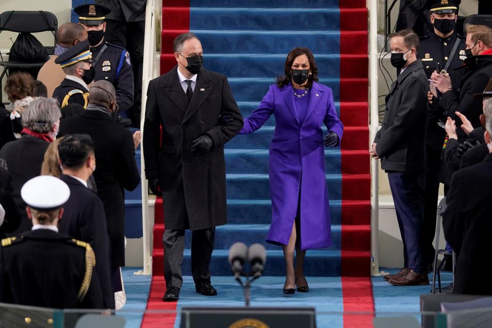 U.S. Vice President-elect Kamala Harris and her husband, Doug Emhoff arrive at the Capitol for inauguration. Harris wore a purple outfit – the color of unity – by two Black designers.  / Credit: PATRICK SEMANSKY/AFP via Getty Images
