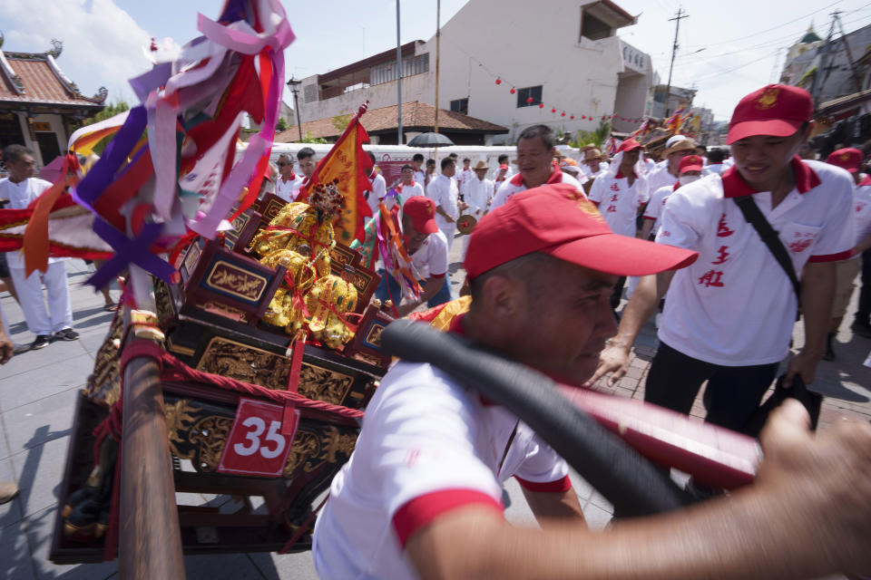 Ethnic Chinese devotees carry a sedan chair during their 9 km procession during Wangkang or "royal ship" festival in Malacca, Malaysia, Thursday, Jan. 11, 2024. The Wangkang festival was brought to Malacca by Hokkien traders from China and first took place in 1854. Processions have been held in 1919, 1933, 2001, 2012 and 2021. (AP Photo/Vincent Thian)