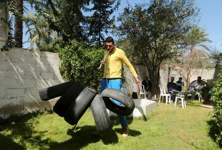 Palestinian Mohammad Baraka, 20, nicknamed by people as Gaza Samson, drags tyres by a rope attached to his teeth as he exercises in Deir al-Balah in the central Gaza Strip March 5, 2016. REUTERS/Mohammed Salem