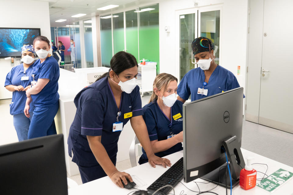 Overwhelmed hospital workers looking at a computer