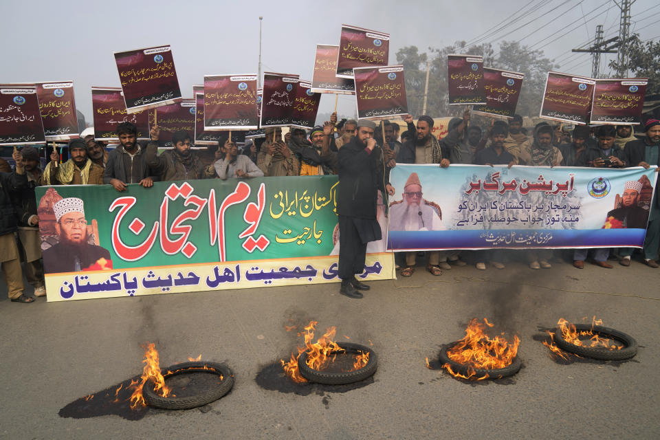 Supporters of a religious group 'Markazi Jamiyat Ahle Hadith Pakistan' burn tires and hold a demonstration to condemn Iran strike in the Pakistani border area, in Lahore, Pakistan, Friday, Jan. 19, 2024. The unprecedented attacks by both Pakistan and Iran on either side of their border appeared to target Baluch militant groups with similar separatist goals. The countries accuse each other of providing a haven to the groups in their respective territories. The banner in Urdu language on left, reads "Protest against Irani aggression". (AP Photo/K.M. Chaudary)