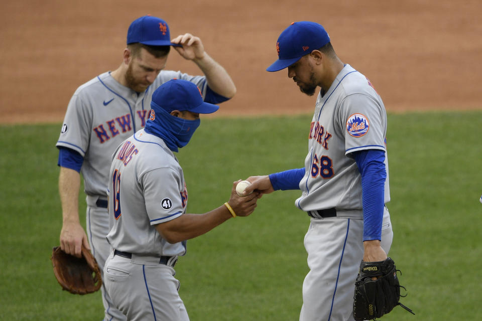 New York Mets relief pitcher Dellin Betances (68) is pulled by manager Luis Rojas, front left, during the sixth inning of a baseball game against the Washington Nationals, Sunday, Sept. 27, 2020, in Washington. Mets third baseman Todd Frazier, back left, looks on. (AP Photo/Nick Wass)