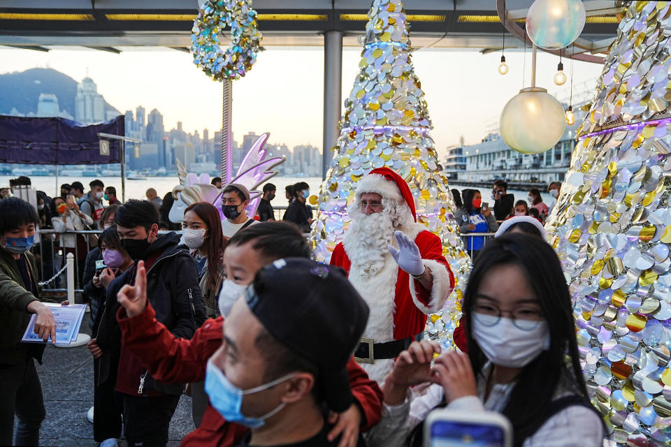 People pose with a performer dressed as Santa Claus during a Christmas lighting ceremony at a shopping mall in Hong Kong, China December 24, 2022. REUTERS/Lam Yik