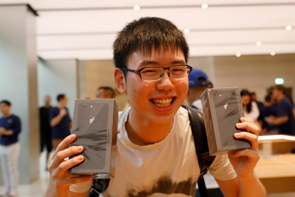 Student Varis Sinthopruangchai poses with his iPhone 8 and his iPhone 8 Plus at the Apple Orchard Shop in Singapore