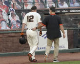 San Francisco Giants' Alex Dickerson (12) walks off the field with the team trainer after getting hit by a ball that bounced off his bat during the fifth inning against of a baseball game against the Arizona Diamondbacks, Monday, Sept. 7, 2020, in San Francisco. (AP Photo/Tony Avelar)