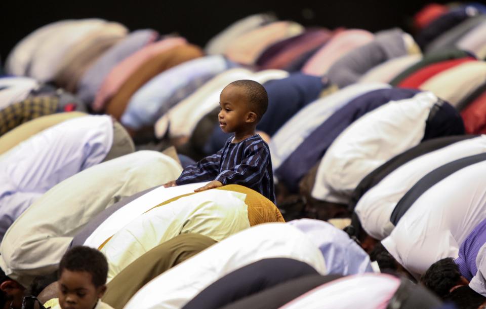 In a file photo, 2-year-old Ahmad Cabbie of Wilmington rests his hands on the back of his father, Umar, while he prayed during the Muslim holiday Eid al-Fitr at the Chase Center on the Riverfront in Wilmington.