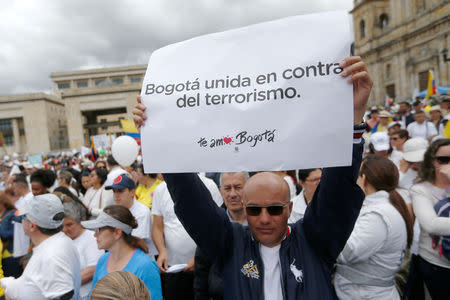 People take part in a rally against violence, following a car bomb explosion, in Bogota, Colombia January 20, 2019. The placard reads, "Bogota gets together against terrorism". REUTERS/Luisa Gonzalez