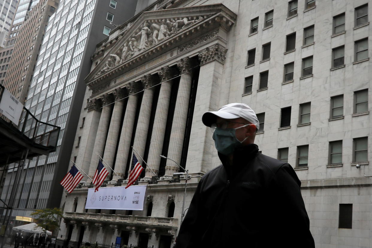 A man wearing a protective face mask walks past the New York Stock Exchange in Manhattan in New York City, New York, U.S., October 26, 2020. REUTERS/Mike Segar