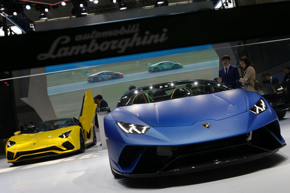 Staff members chats with visitors near the Lamborghini Huracan models on being displayed at the China Auto China in Beijing, Thursday, April 26, 2018. Auto China 2018, the industry's biggest sales event this year, is overshadowed by mounting trade tensions between Beijing and U.S. President Donald Trump, who has threatened to hike tariffs on Chinese goods including automobiles in a dispute over technology policy. (AP Photo/Andy Wong)