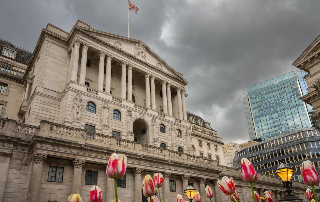 London, UK: Bank of England building in the City of London with tulips in the foreground. UK business confidence
