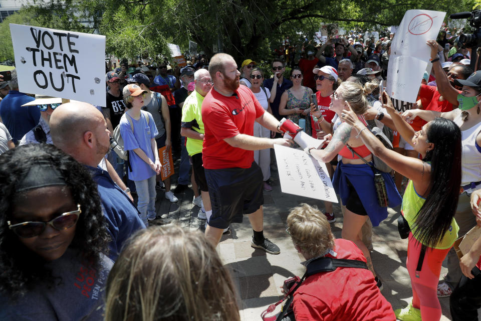 A counter protester, center, is shouted down and has his megaphone taken away by rally attendees for pro-gun control efforts at Discovery Green Park, across the street from the National Rifle Association Annual Meeting held at the George R. Brown Convention Center Friday, May 27, 2022, in Houston. (AP Photo/Michael Wyke)