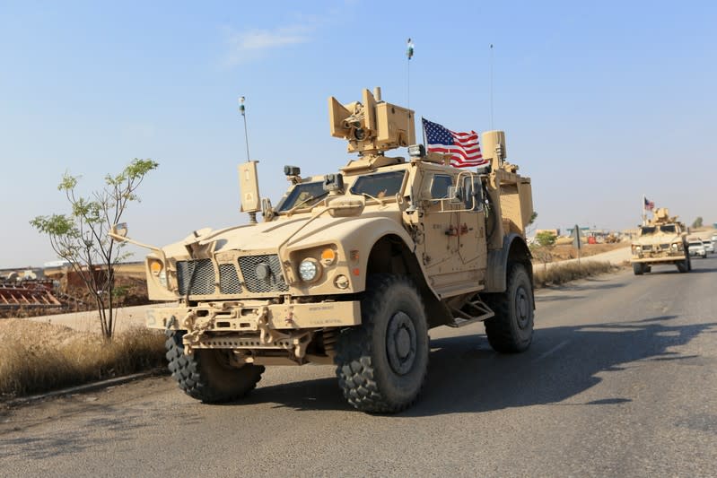 A convoy of U.S. vehicles is seen after withdrawing from northern Syria, at the Iraqi-Syrian border crossing in the outskirts of Dohuk