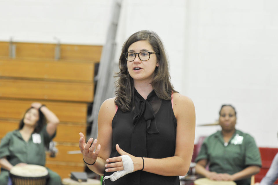 Amy Garapic explains to inmates a song requiring audience participating in the form of chanting and clapping. Despite having a broken finger, Garapic still played bongos along with the inmates.