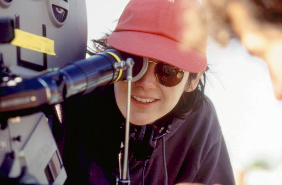 Amy Heckerling in a pink baseball cap directing Clueless