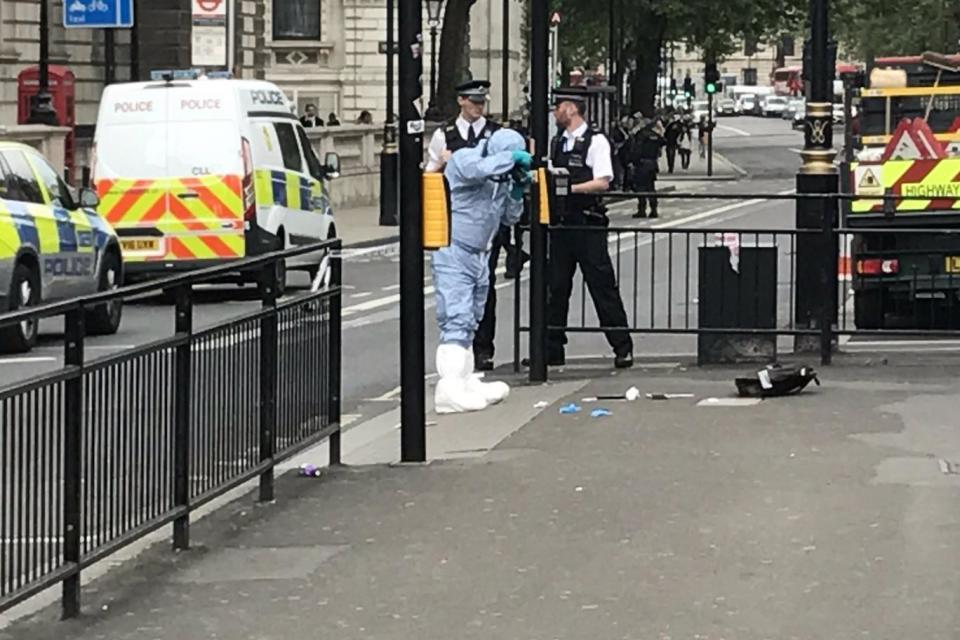 A forensics officer photographing a discarded bag. (Guido Fawkes)