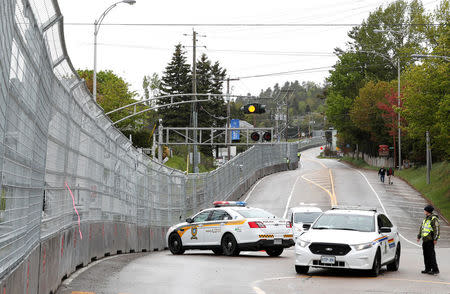 Canadian police keep guard next to a security fence built around the red zone security perimeter around the Manoir Richelieu ahead of G7 Summit in La Malbaie, Canada June 5, 2018. REUTERS/Yves Herman