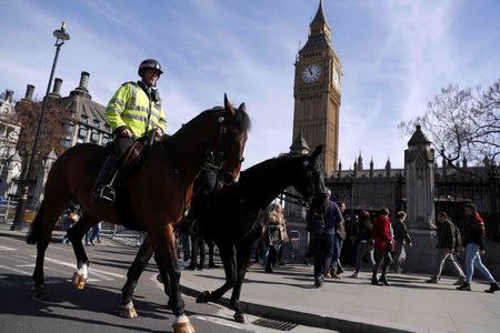 Two mounted police officers ride past the Houses of Parliament, following the attack in Westminster earlier in the week, in London, Britain March 25, 2017. REUTERS/Peter Nicholls